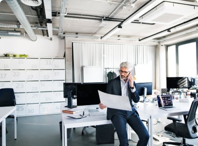 man looking at document while speaking on the phonw