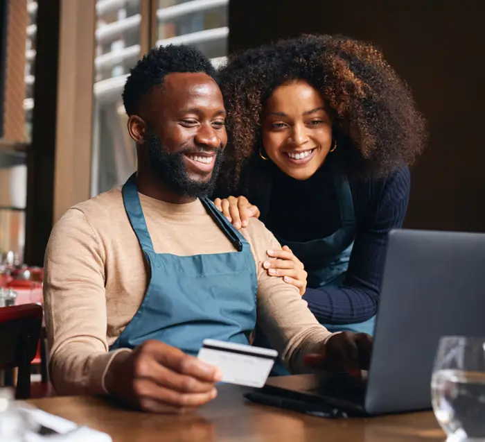 An iamge of a couple in front of a laptop
