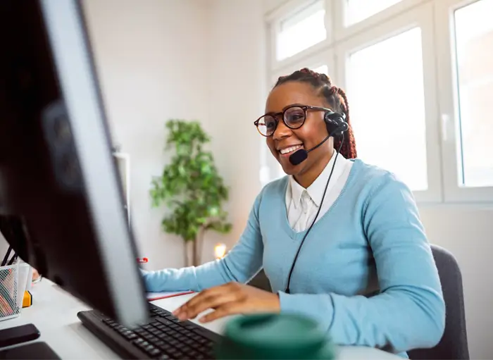 An image of a support agent infront of her computer.