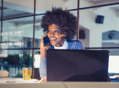women on phone working on Laptop