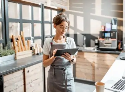 women in apron with tablet