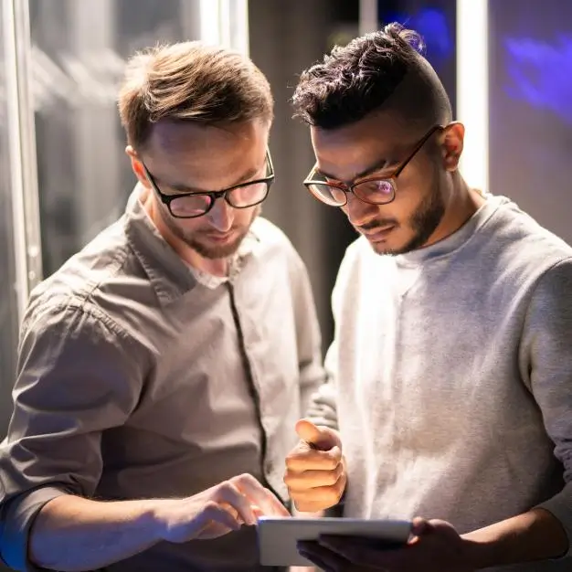 two men looking at a tablet