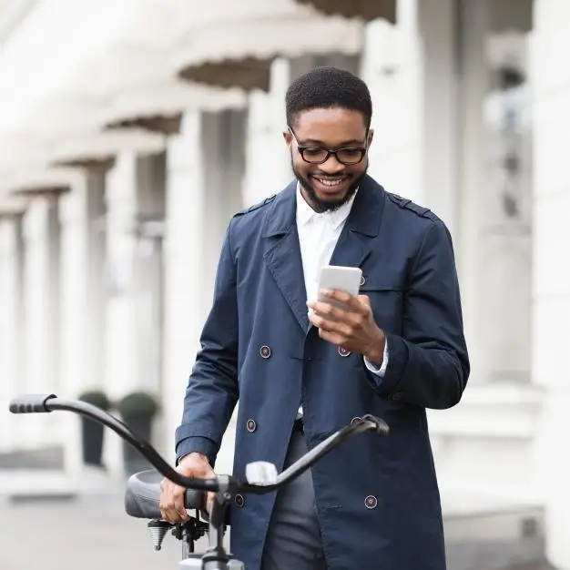 male holding bicycle and looking at his cellphone