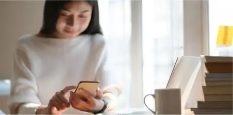lady using phone with cup on her table