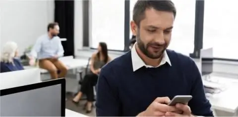Man messaging on phone in the office