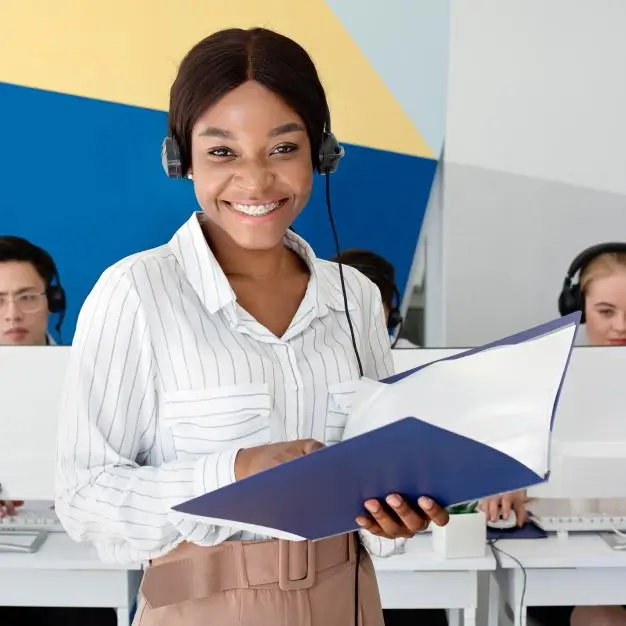 Lady with head set on holding a file and smiling at camera