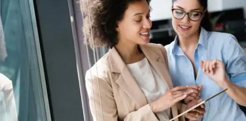 two women looking at a tablet
