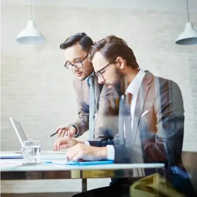 two men working from a laptop