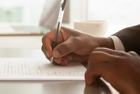 man's hand writng a document