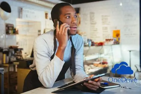 Man talking on the phone while holding a tablet