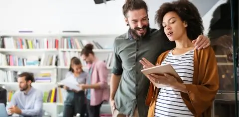 two people taling and looking at a tablet