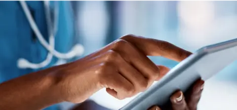 A doctor's hands using a tablet