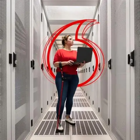 Women standing in server room with her laptop