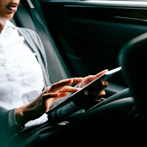 person sittig in the car working on their tablet