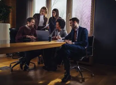 People meeting in boardroom looking at a computer and talking