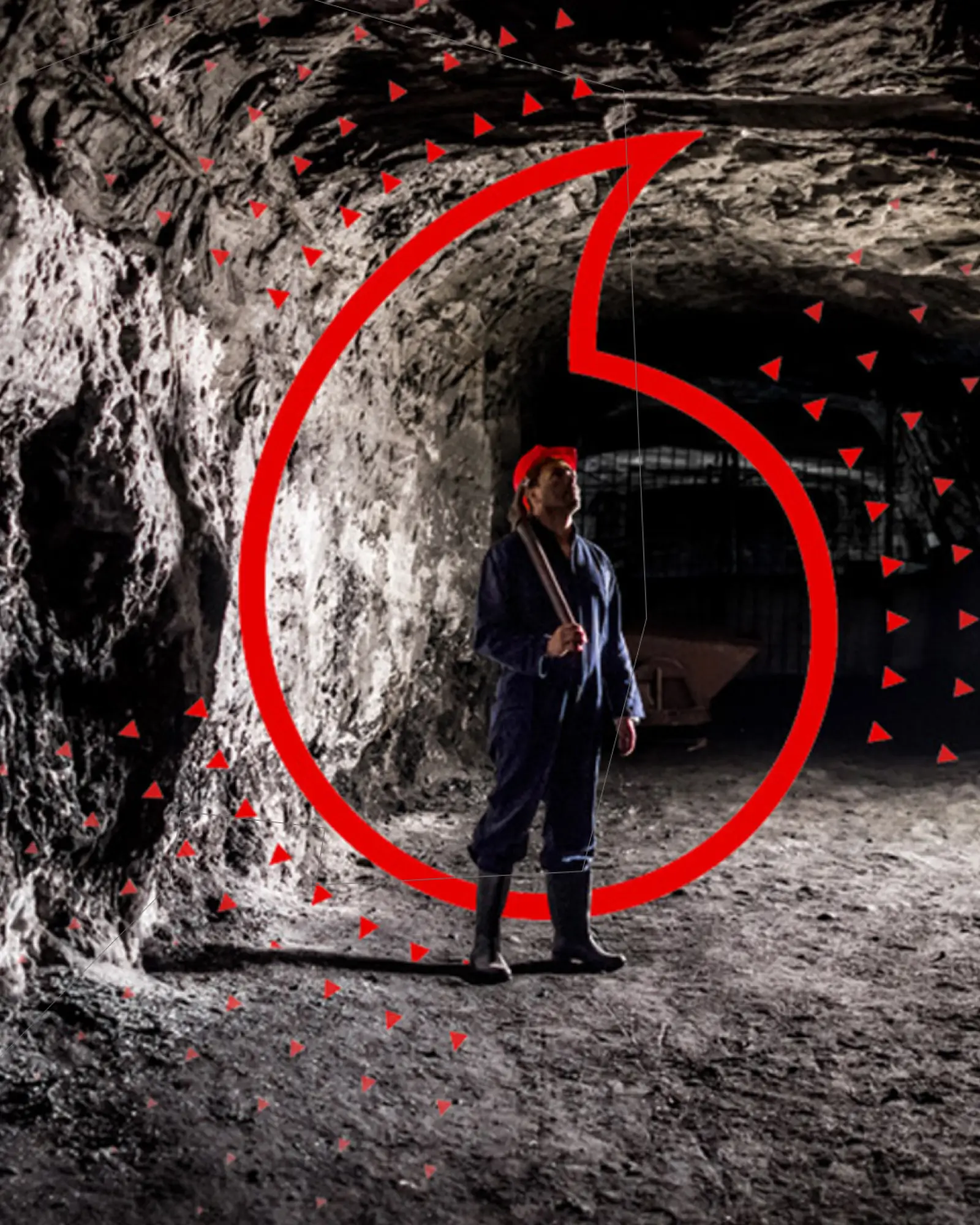 A miner holding a pickax standing in a mine shaft