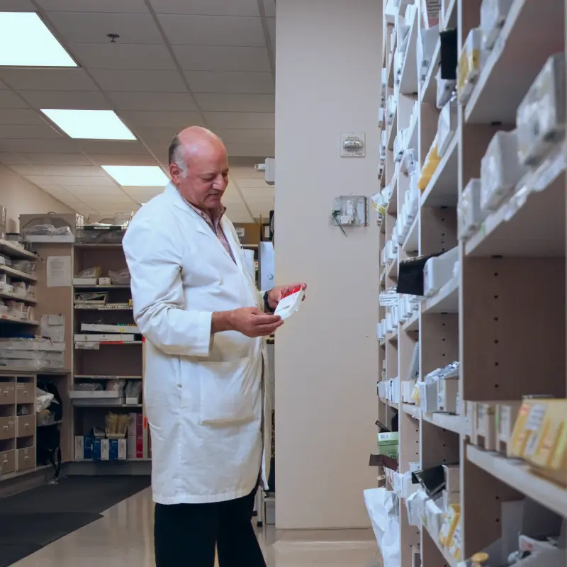 Male pharmacist looking at medication