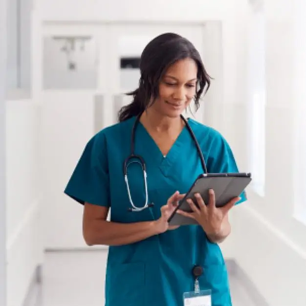 Nurse walking with a tablet in her hand