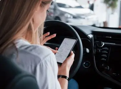 women looking at phone in car