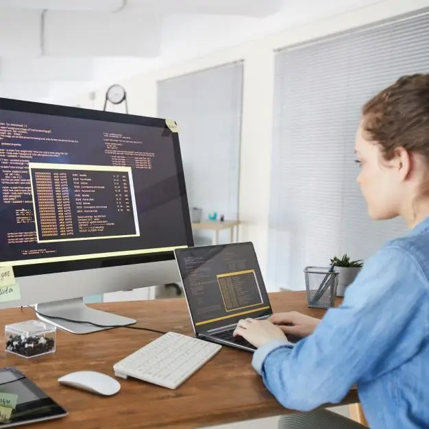 women working on laptop and extra screen in in an office