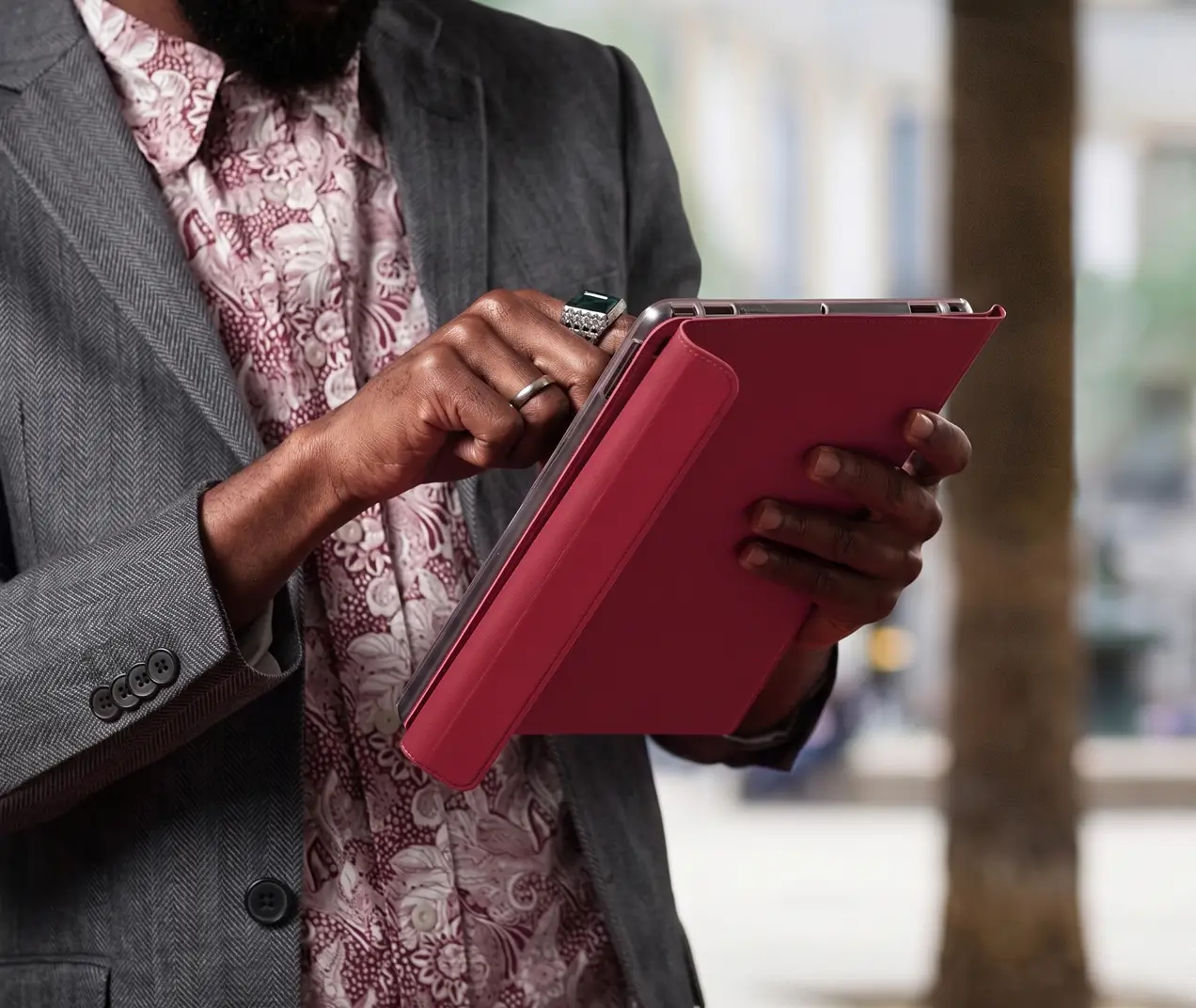 Close up of a businessman in a gray suit using a digital tablet with a pink case
