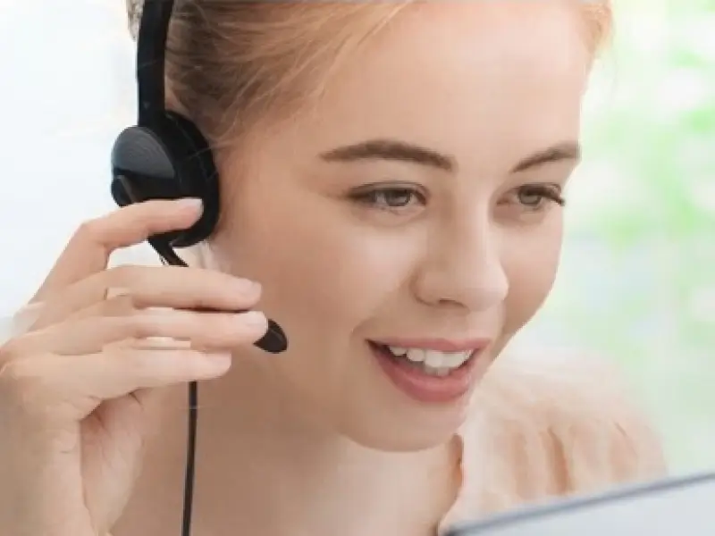 Customer support representative wearing a headset and smiling