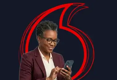 "Smiling woman wearing glasses and a blazer while using a smartphone against a dark background with a red graphic design