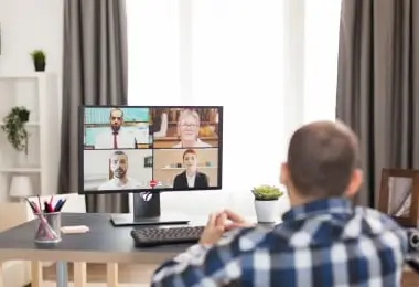 Man participating in a video call on his computer from a home office