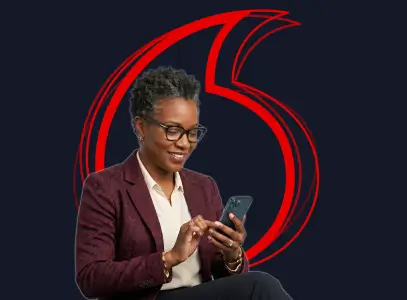 Woman with short hair and glasses using a smartphone in front of a red Vodafone logo background